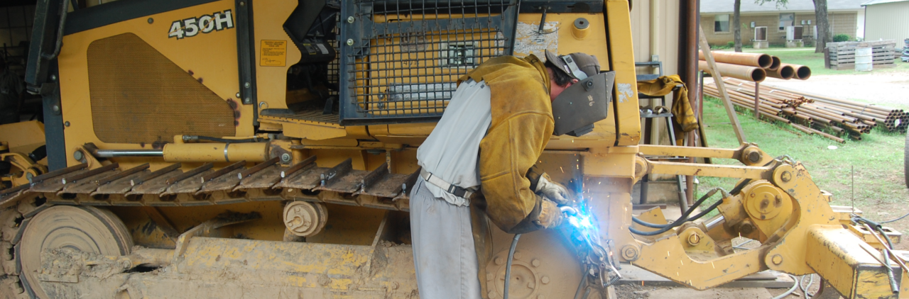Man welding on heavy machinary